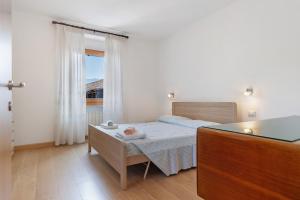 a bedroom with a bed and a table and a window at Appartamenti Panelatti in Bono