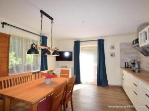 a kitchen and dining room with a wooden table in a room at Ferienwohnung Petra in Kössen +7 photos