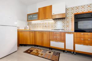 a kitchen with wooden cabinets and a white refrigerator at Appartamenti Panelatti in Bono +38 photos