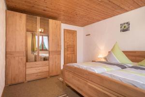 a bedroom with a large bed and a mirror at Ferienhof Wetzel Fewo 1 in Hergensweiler