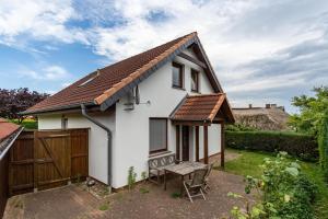 a small white house with a wooden fence at Haus Seeblick in Putbus