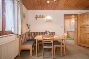 a dining room with a wooden table and chairs at Ferienhof Wetzel Fewo 1 in Hergensweiler