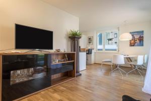 a living room with a flat screen tv on a entertainment center at Sunny Appartment in Bregenz
