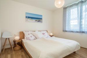 a bedroom with a bed with white sheets and a window at Sunny Appartment in Bregenz