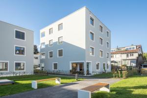 a white building with a bench in front of it at Sunny Appartment in Bregenz