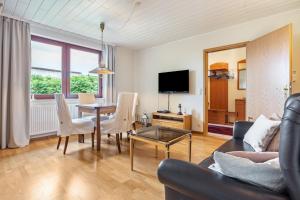 a living room with a table and chairs and a tv at Haus Seeblick in Putbus