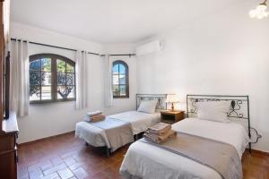 two beds in a room with two windows at Villa Rústica in Albufeira +37 photos