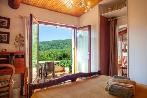 a bedroom with a bed and a large sliding glass door at Les Oiseaux in Ceyreste