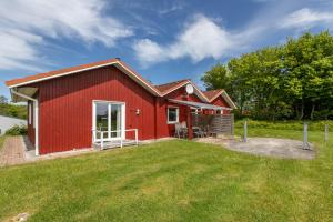 a red house with a large yard in front of it at Ferienwohnung Saustrup in Saustrup