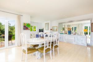 a white dining room with a white table and chairs at La Vinya del Beato 1950 in Port de Pollensa