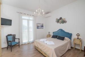 a bedroom with a bed and a blue chair at Maison Chloe 2 in La Maddalena