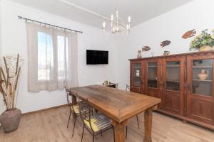 a dining room with a wooden table and a cabinet at Maison Chloe 2 in La Maddalena