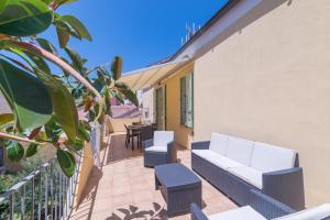 a patio with a couch and chairs on a balcony at Maison Chloe 2 in La Maddalena