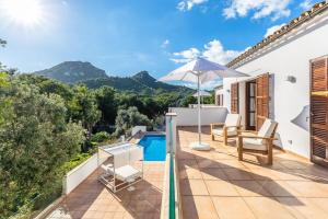 a villa with a swimming pool and an umbrella at Villa Font de sa Cala in Font de Sa Cala