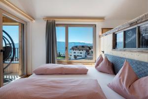 a bedroom with a bed with a large window at Moarhof in Meltina