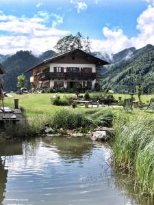 a house with a river in front of a building at Ferienwohnung Rauschberg in Ruhpolding