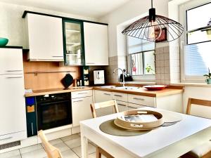 a kitchen with white cabinets and a white table at Lichte Wohnung zum Wohlfühlen in Bastheim