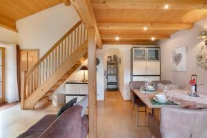 a dining room and living room with a wooden staircase at Ferienwohnung Rauschberg in Ruhpolding +14 photos