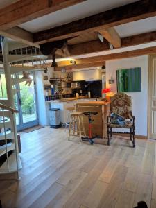 a living room with a kitchen with wooden floors at La maison du vigneron in Auzon +20 photos