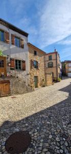a cobblestone street with two buildings and a building at La maison du vigneron in Auzon