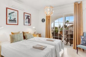a white bedroom with two beds and a window at Villa Cempo V215 in La Cala de Mijas +24 photos