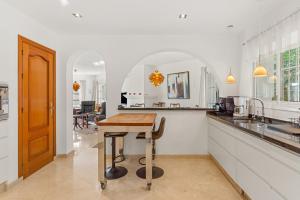 a kitchen with a wooden table and a counter at Villa Cempo V215 in La Cala de Mijas
