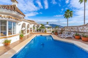 a villa with a swimming pool and a house at Villa Cempo V215 in La Cala de Mijas