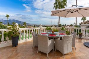 a patio with a table and chairs and an umbrella at Villa Cempo V215 in La Cala de Mijas