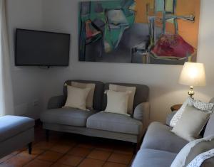 a living room with two couches and a flat screen tv at Casa Rural Fuentebuena in Matabuena +12 photos