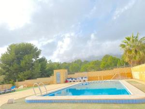 a large swimming pool next to a brick wall at Alberca La Nucia in Polop