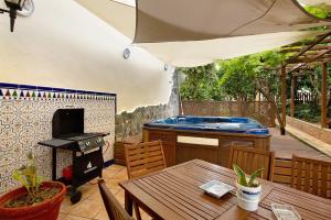 an outdoor patio with a hot tub and a grill at Carmelo y Carmela 1 in Teror