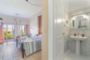 a bathroom with a bed and a sink in a room at Christianna studios in Nikiana +127 photos