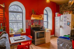 a kitchen with red walls and a table and a stove at Auberge Alternative in Montreal
