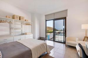 a white bedroom with a bed and a balcony at Urban Park Girasol in Los Llanos de Aridane