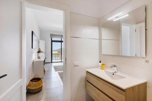 a white bathroom with a sink and a mirror at Urban Park Girasol in Los Llanos de Aridane