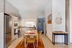 a kitchen and dining room with a table and chairs at Urban Park Girasol in Los Llanos de Aridane +13 photos