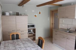 a kitchen with a table and chairs and a kitchen with wooden cabinets at Ferienwohung Stelldichein in Altenbrak