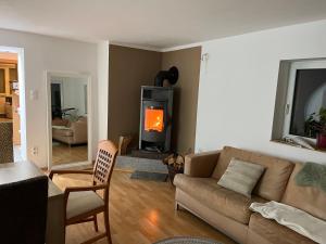 a living room with a couch and a fireplace at Wohnung mit Dachterasse in Absberg