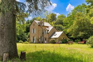 an old brick house in a field with a tree at Chambre d'hôtes Kerdary in Nivillac