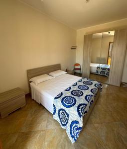 a bedroom with a large bed with a blue and white blanket at Da Katia in Arnesano