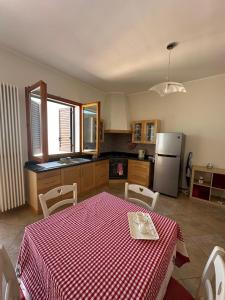 a kitchen with a table with a red and white checkered table cloth at Da Katia in Arnesano