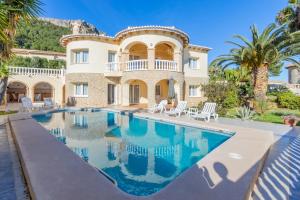 a villa with a swimming pool in front of a house at Villa Cucarres in Calpe