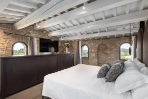 a bedroom with a large white bed in a brick wall at Suite Deluxe Torre in San Gimignano +20 photos