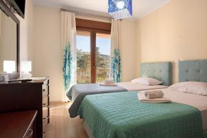 two beds in a room with a window at Villa Totta in Alikanas +37 photos
