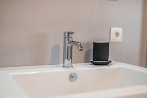 a sink with a faucet and a cup on it at Plose 35 in Bressanone +14 photos
