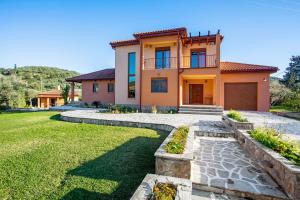 a house with a green yard in front of it at Villa Totta in Alikanas