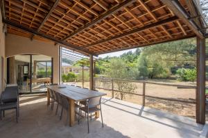 an outdoor patio with a wooden table and chairs at Villa Luminières I in Sallelles
