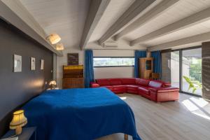 a bedroom with a blue bed and a red couch at Villa Luminières I in Sallelles