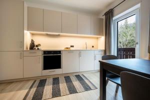 a kitchen with white cabinets and a dining table at Plose 35 in Bressanone