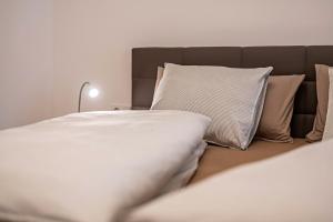 a bed with white sheets and pillows in a room at Plose 35 in Bressanone